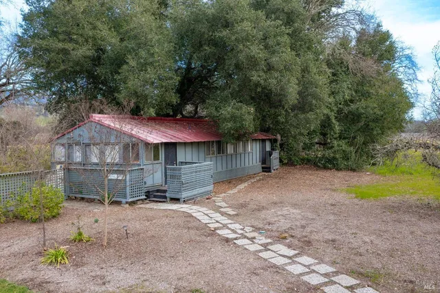 a view of a house with a yard and large tree