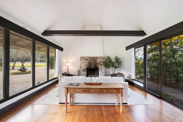 a living room with fireplace furniture and a floor to ceiling window
