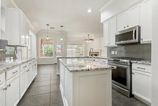 a view of a hallway with wooden floor and a chandelier