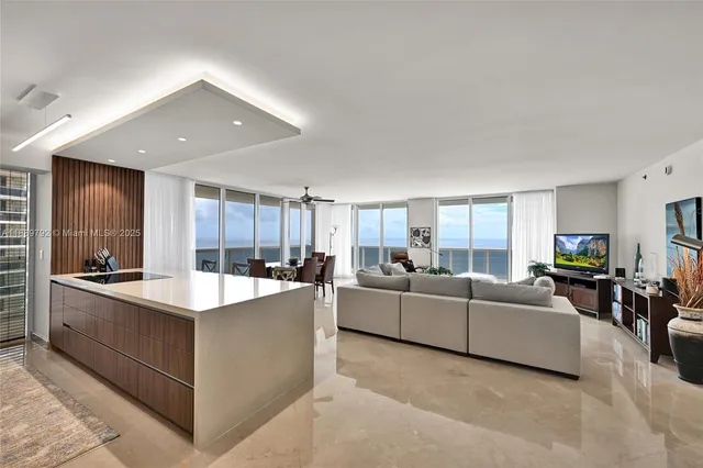 a large living room with stainless steel appliances kitchen island granite countertop a large counter top and couches