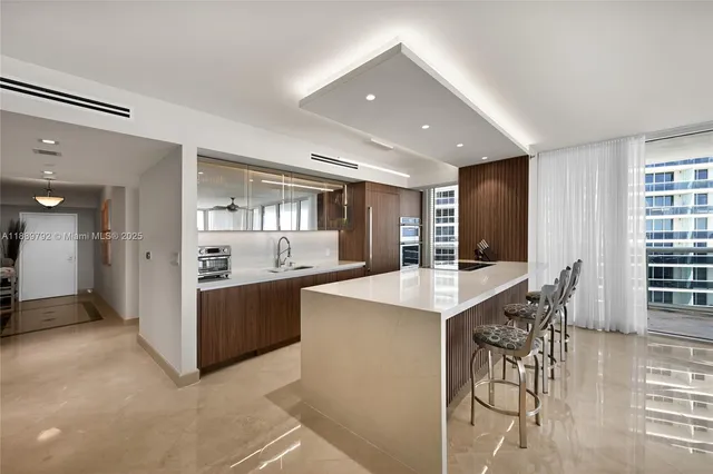 a kitchen with stainless steel appliances kitchen island granite countertop a refrigerator and a stove