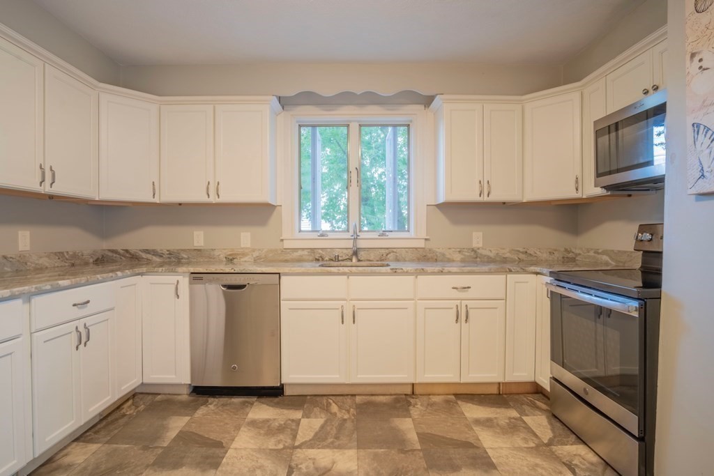 10 Maple Avenue Danvers, MA 01923 - Photo 15 of 41 a kitchen with granite countertop white cabinets stainless steel appliances a sink and a window