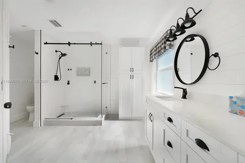 a bathroom with a granite countertop sink a mirror and a shower