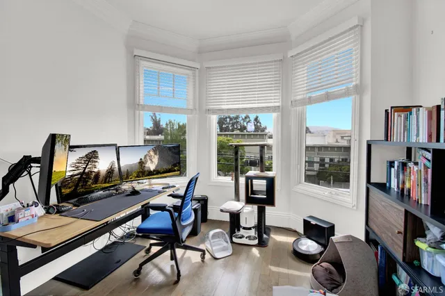 a view of a workspace with furniture and a window