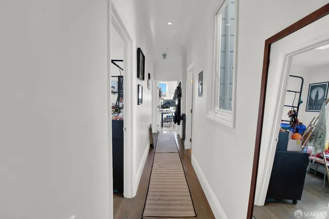a view of a hallway with wooden floor and stairs