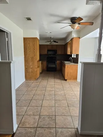 a view of a refrigerator in kitchen and a window