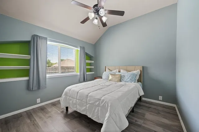 a spacious bedroom with a bed a couch and a chandelier