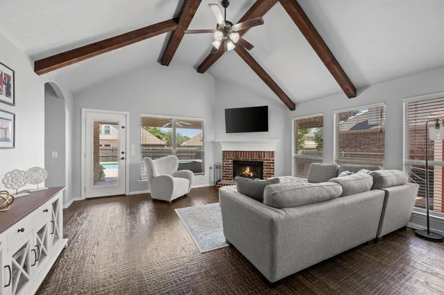 a living room with furniture a fireplace and a floor to ceiling window