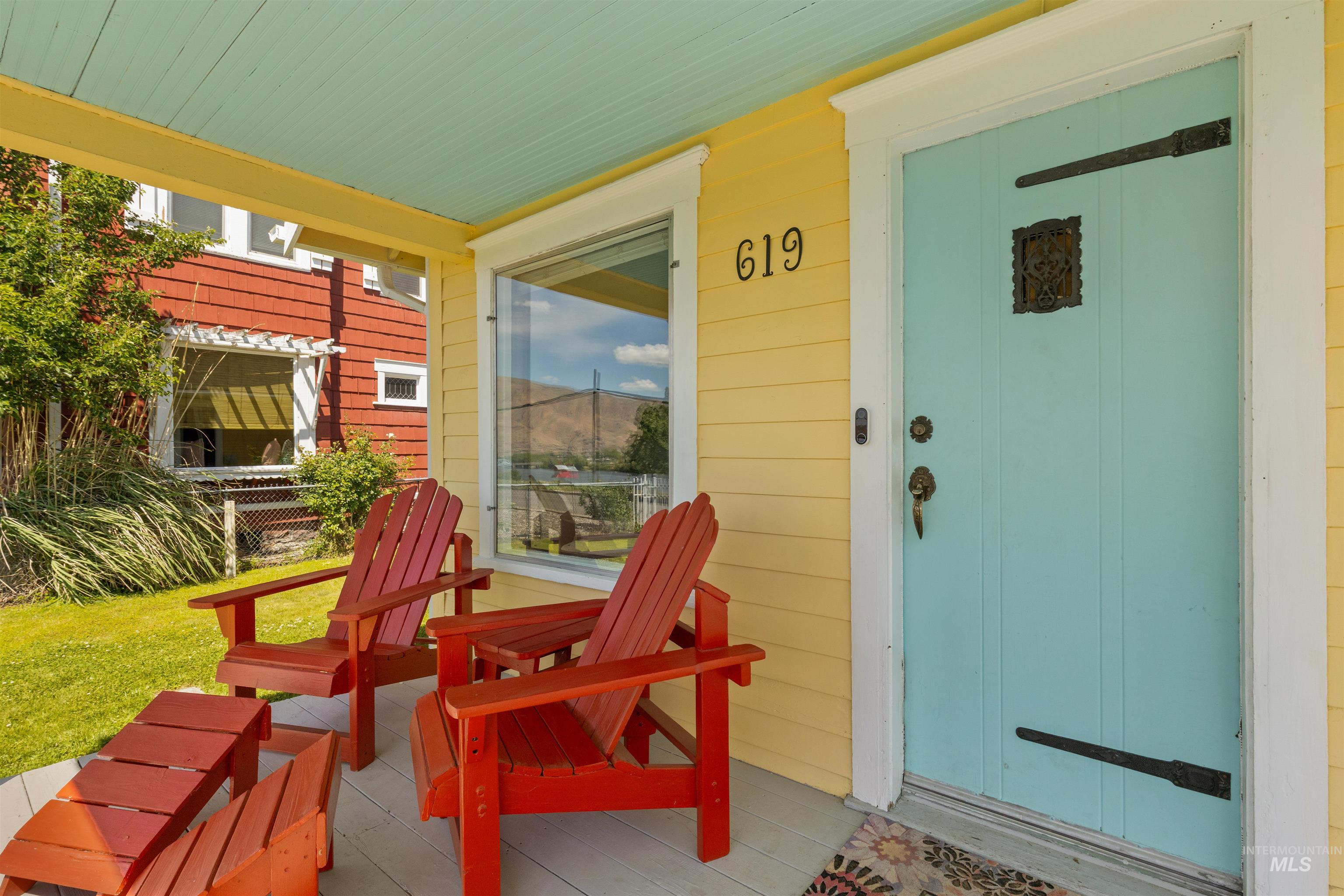 619 Prospect Avenue Lewiston, ID 83501 - Photo 6 of 37 Charming covered porch featuring a vibrant blue entry door with decorative hardware, yellow siding, white trim, and a light blue porch ceiling