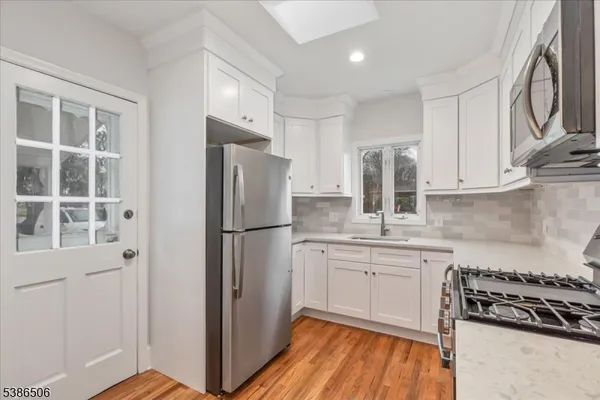a kitchen with stainless steel appliances granite countertop a refrigerator and a stove top oven