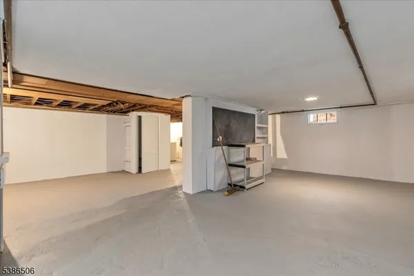 a view of empty room with a walk in closet and window