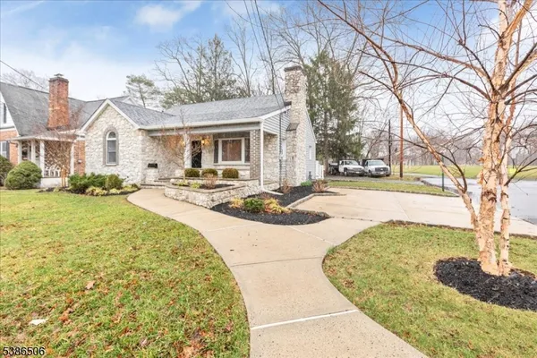 a front view of a house with a yard and trees