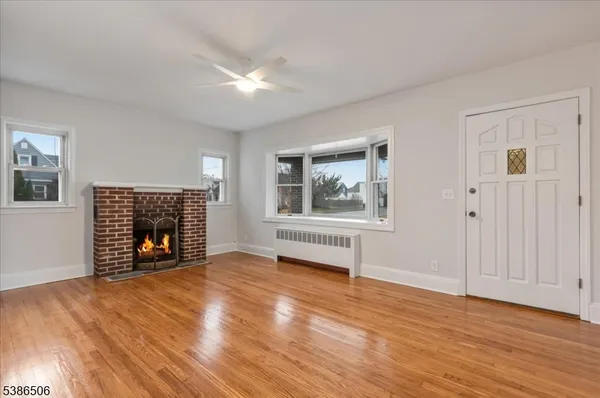 a view of an empty room with a window and fireplace