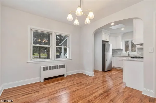 a view of a kitchen with wooden floor and a large window