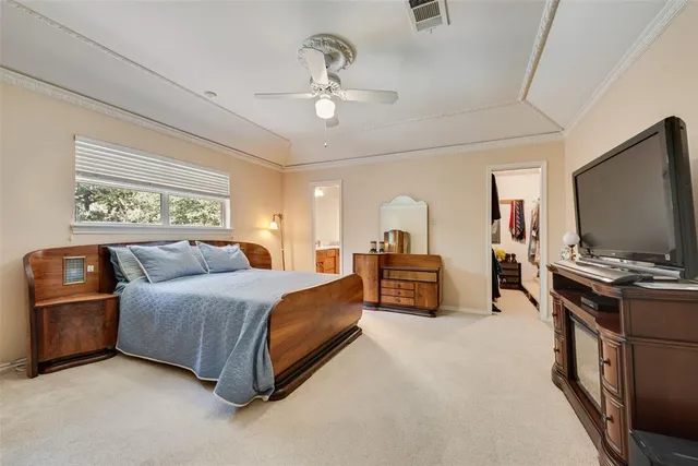 a spacious bedroom with a bed and a flat screen television