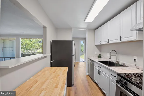 a kitchen with granite countertop white cabinets and stainless steel appliances