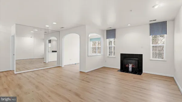 an empty room with wooden floor and a fireplace
