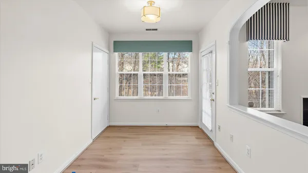 an empty room with wooden floor and windows