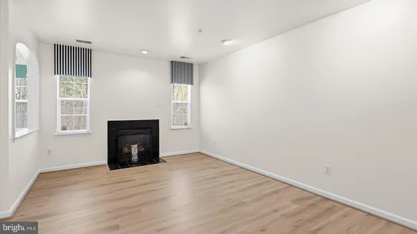 a view of empty room with wooden floor and fireplace