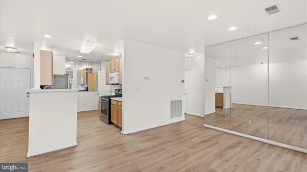 a view of a kitchen with refrigerator and wooden floor