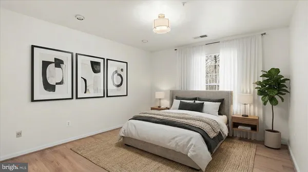a bedroom with a large bed and a potted plant
