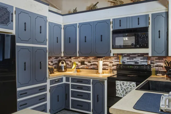 a kitchen with kitchen island a counter top space stainless steel appliances and cabinets