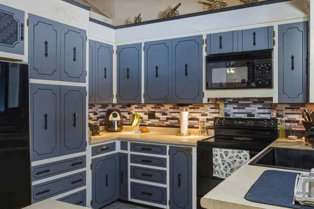 a kitchen with kitchen island a counter top space stainless steel appliances and cabinets