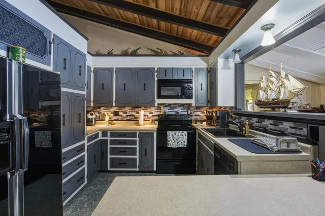 a kitchen with stainless steel appliances granite countertop a stove a sink and a refrigerator