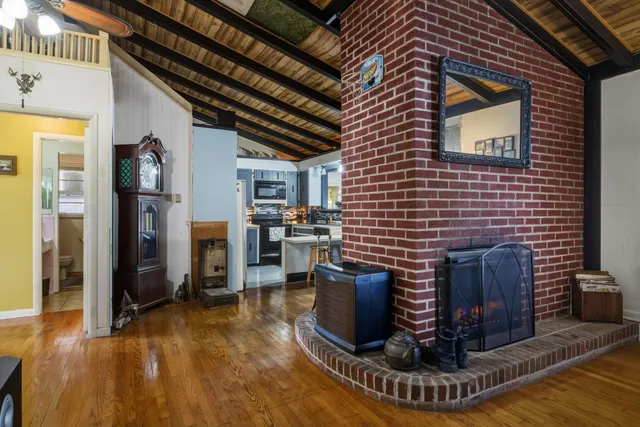 a living room with furniture a fireplace wooden floor and a rug
