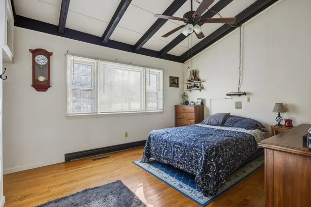 a bedroom with a bed and a view of living room