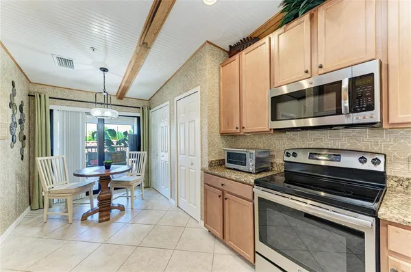 a kitchen with a stove a microwave and cabinets