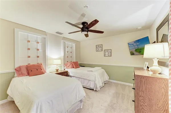 a bedroom with two beds and a chandelier