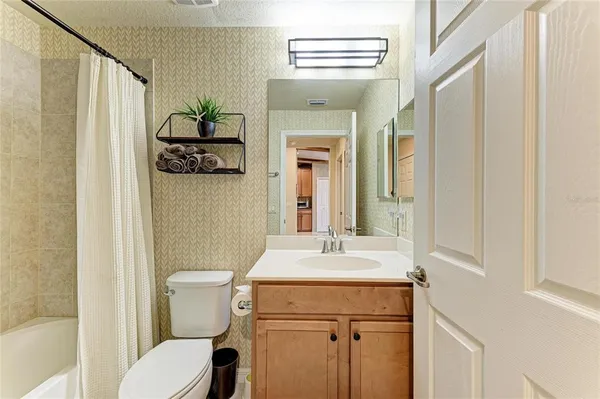 a bathroom with a sink a toilet and shower curtain