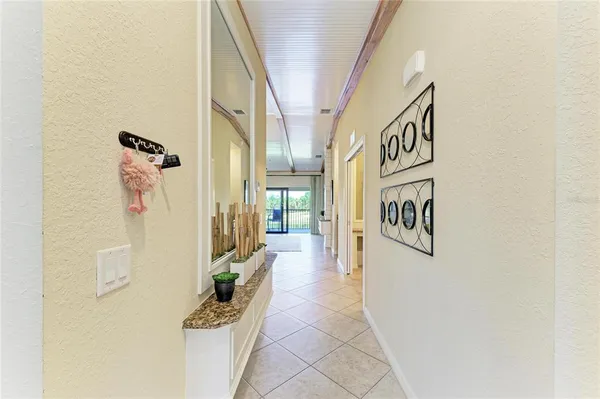 a hallway with painting on the wall and a potted plant