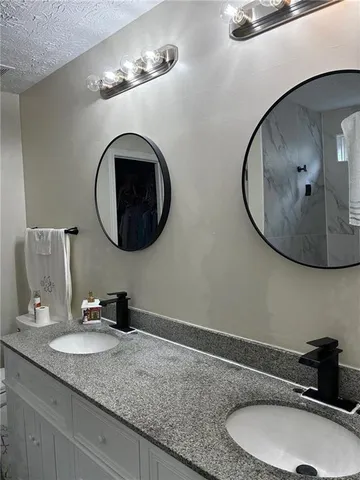 a bathroom with a double vanity sink and a mirror