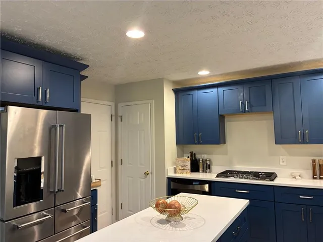 a kitchen with stainless steel appliances granite countertop a refrigerator stove a sink and dishwasher