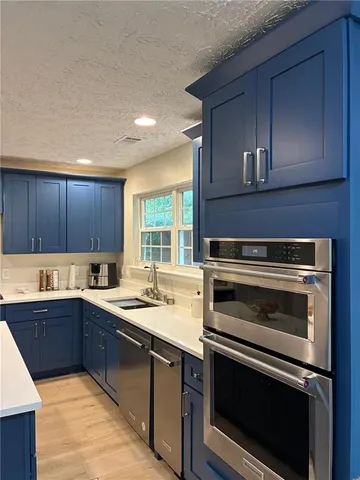 a kitchen with a sink stove and microwave