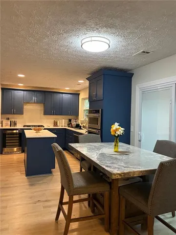 a kitchen with granite countertop kitchen island stainless steel appliances and wooden cabinets