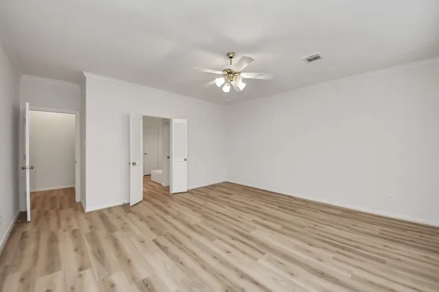 a view of empty room with wooden floor