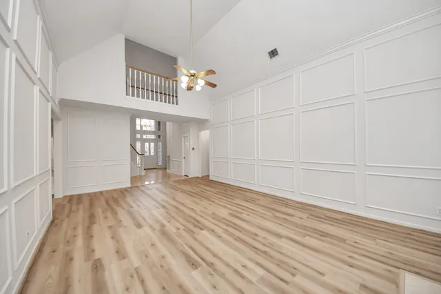 a view of an empty room with window and wooden floor