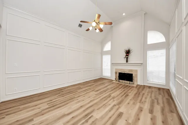 a view of a livingroom with an empty space & a window