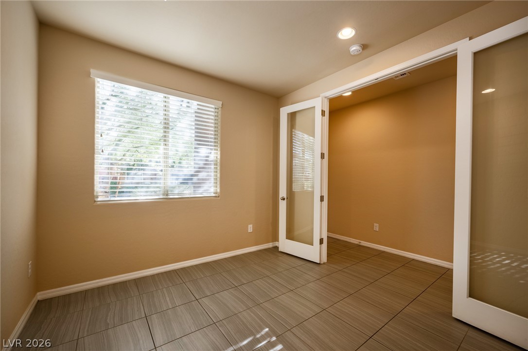 11016 Prairie Grove Road Las Vegas, NV 89179 - Photo 6 of 37 A well-lit room features sleek tile flooring and ample natural light through a large window.