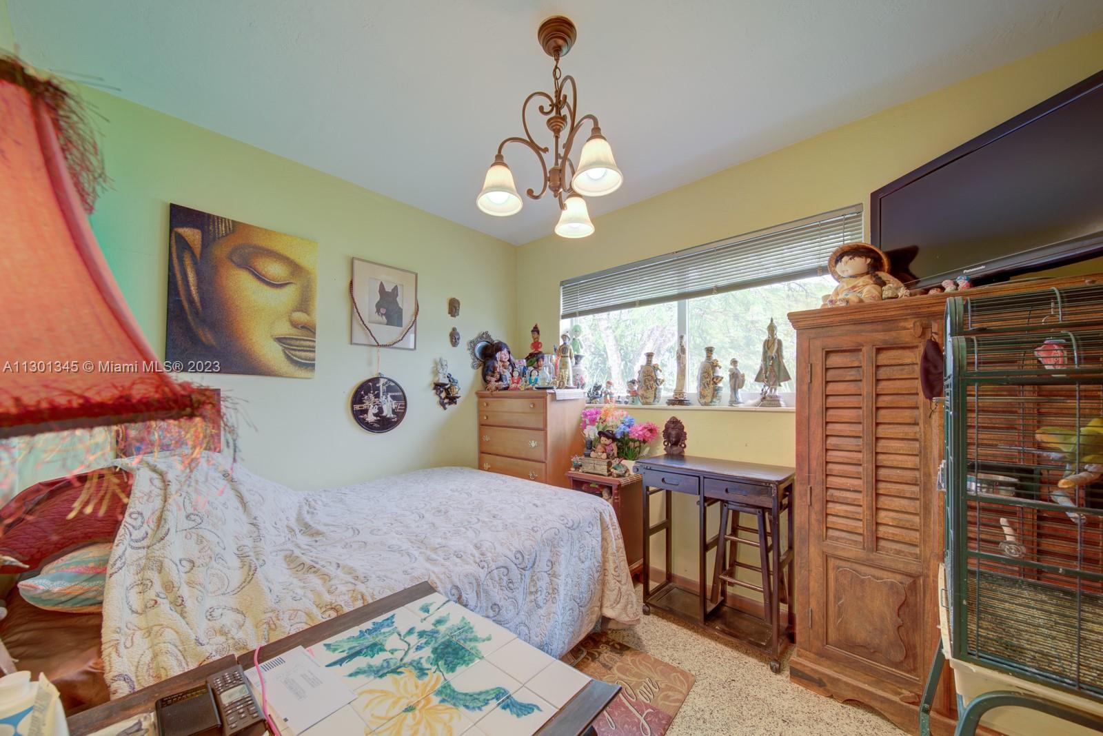 9520 April Road Cutler Bay, FL 33157 - Photo 13 of 26 a bedroom with a bed and a chandelier