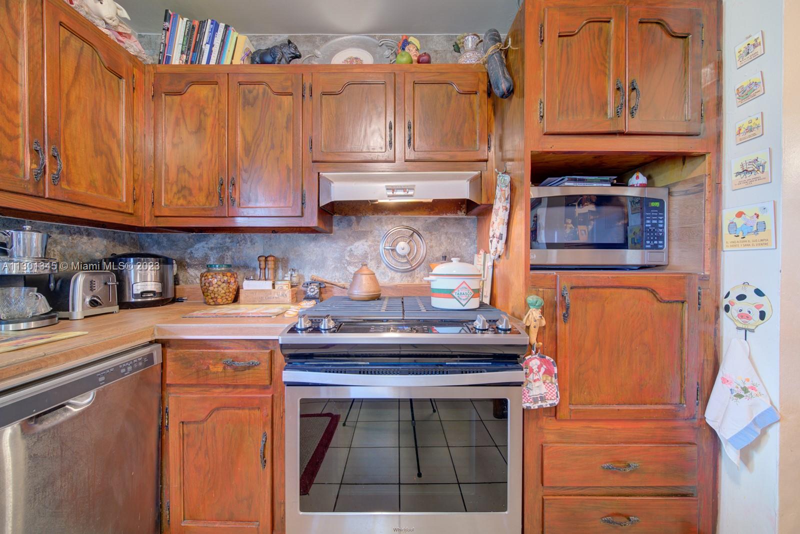 9520 April Road Cutler Bay, FL 33157 - Photo 18 of 26 a kitchen with stainless steel appliances granite countertop a stove and cabinets