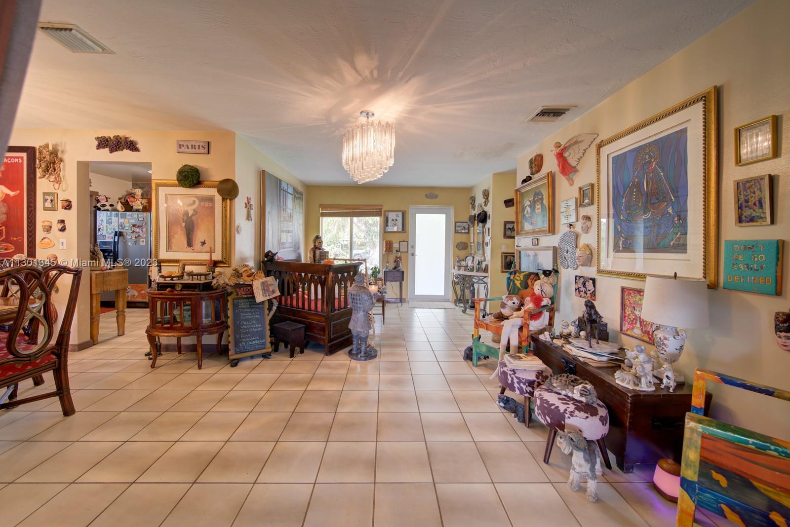 9520 April Road Cutler Bay, FL 33157 - Photo 23 of 26 a living room filled with furniture and a chandelier