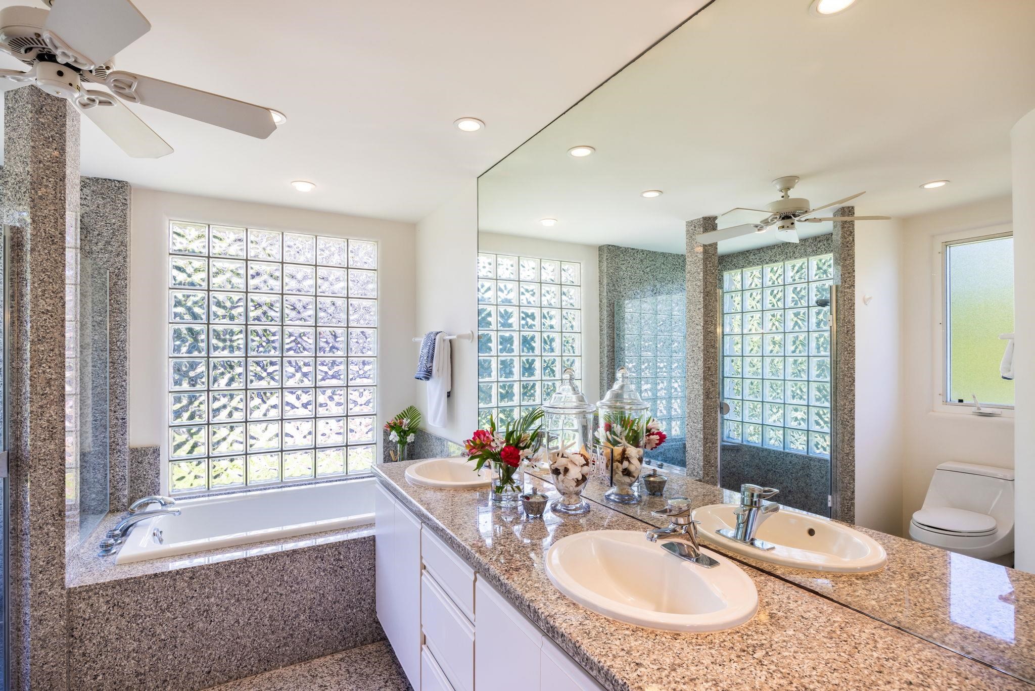 5045 Lower Honoapiilani Road, Unit 9 Lahaina, HI 96761 - Photo 30 of 50 a bathroom with a granite countertop double vanity sink large mirror bathtub and toilet