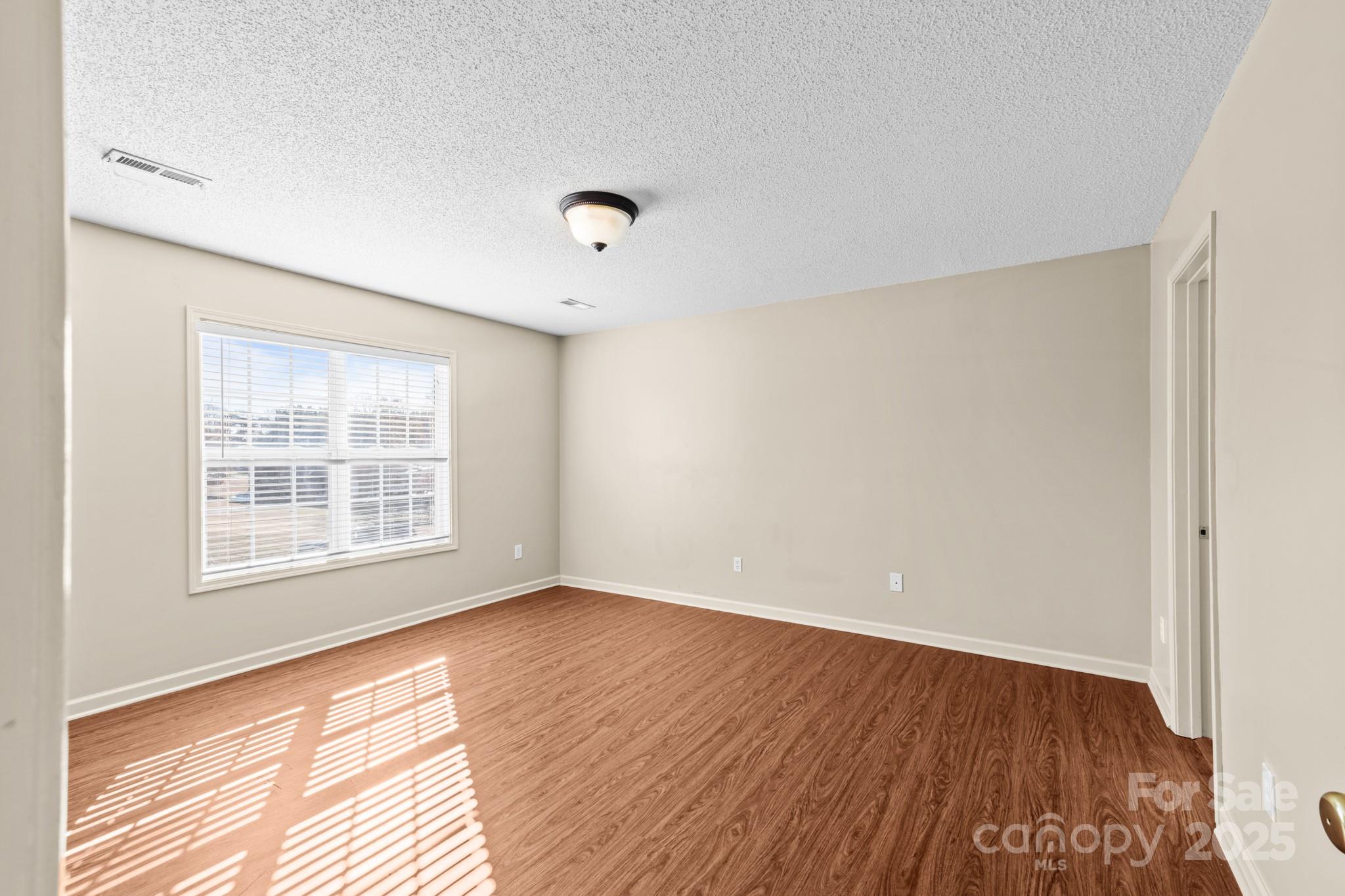 2244 Burris Road Conover, NC 28613 - Photo 11 of 38 an empty room with wooden floor and windows