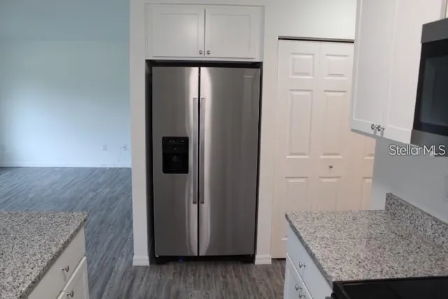 a kitchen with granite countertop a refrigerator and a counter space