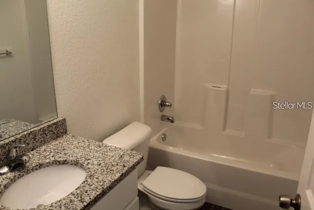 a bathroom with a granite countertop toilet sink and bathtub