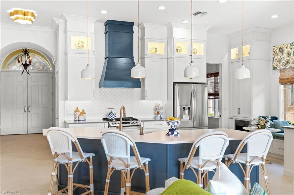 8536 Mallards Way Naples, FL 34114 - Photo 13 of 49 a kitchen with stainless steel appliances kitchen island granite countertop a dining table chairs and a refrigerator